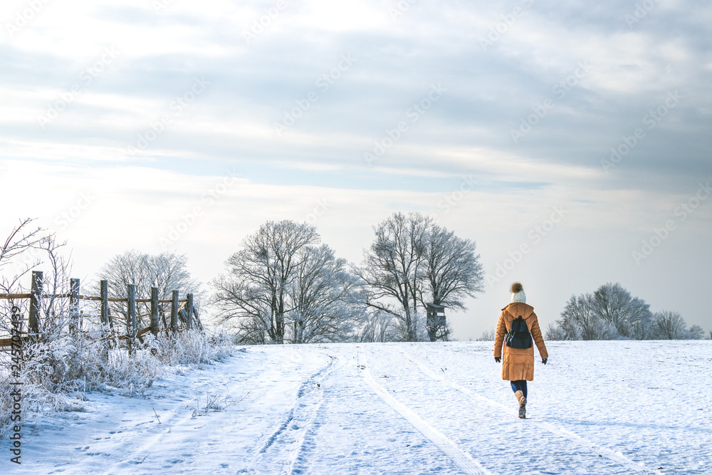Woman walking in snowy winter landscape