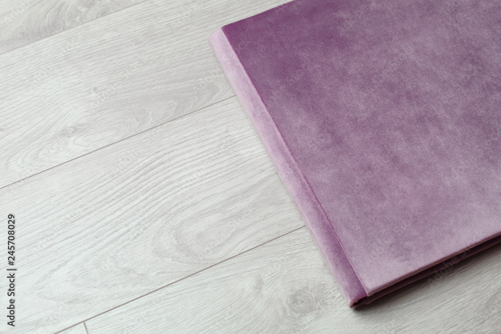 Fototapeta premium photo book of fabric. Photo book on a light background.Photo album with a hard cover on a wooden background. Bright photo album.