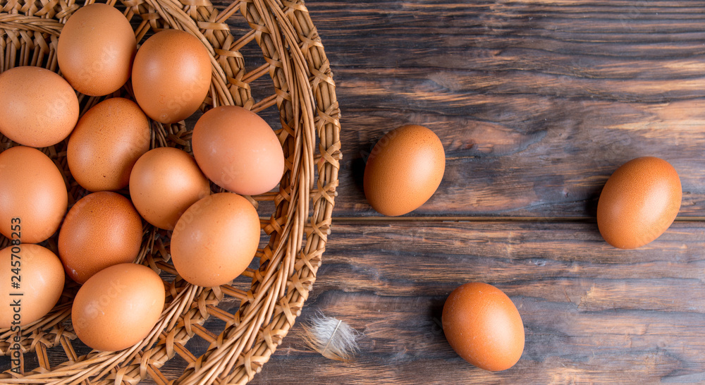 chicken eggs in a straw tray on an old wooden table chicken eggs in a straw tray on an old wooden table