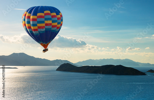 Colorful hot air balloon fly over the blue sea.