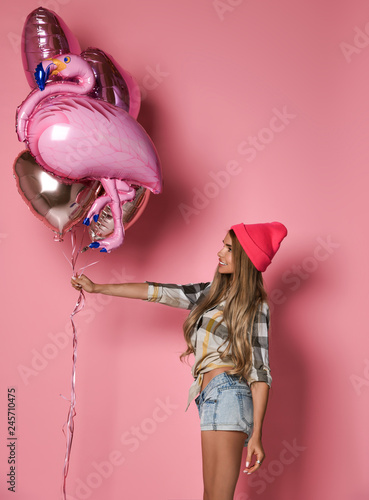 Foto glamorous young girl holds a bunch of balloons and one in the form of a flamingo