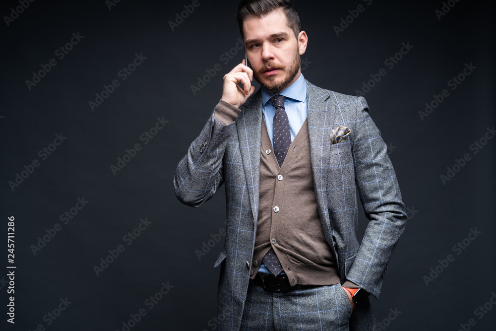 A man in a business suit with a smartphone. Studio portrait. A man in a business suit with a smartphone. Studio portrait.