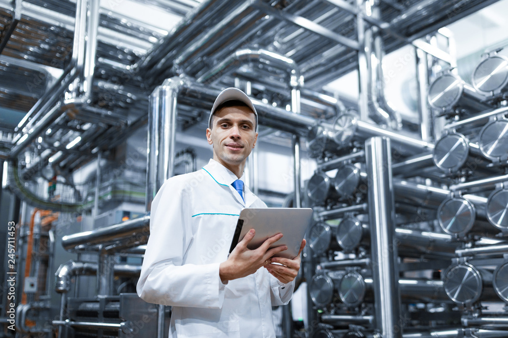Technologist with a tablet in his hands at the dairy plant Technologist with a tablet in his hands at the dairy plant