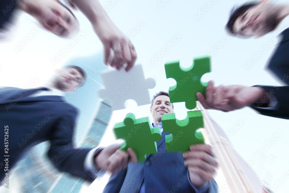 Business people assembling jigsaw puzzle Business people assembling jigsaw puzzle