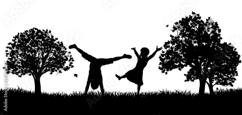 Little kids or children playing in the park or exercising outdoors in silhouette