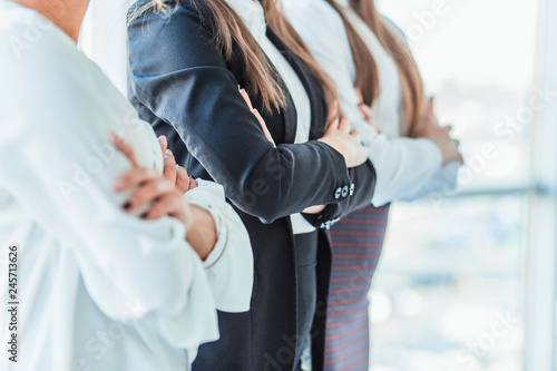 With pleasure, three business women cross their arms, looking at the camera. photo