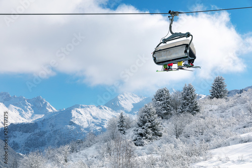 skiers in chairlift above beautiful snowy winter landscape in french Alps