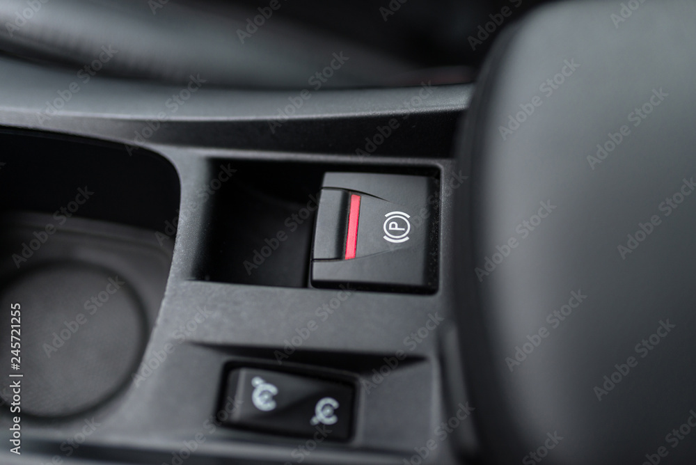 Black interior of a modern car, switch on the electrically assisted parking brake, handbrake.