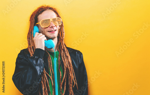 Dreadlocked man talking on old fashioned retro phone