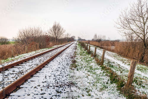 Single-track rails in a winter landscape covered with a layer of snow