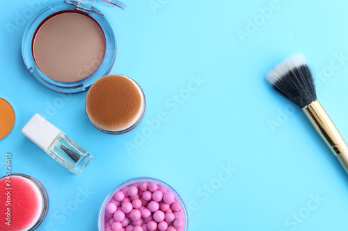Makeup products with cosmetic bag and macaroons on light background