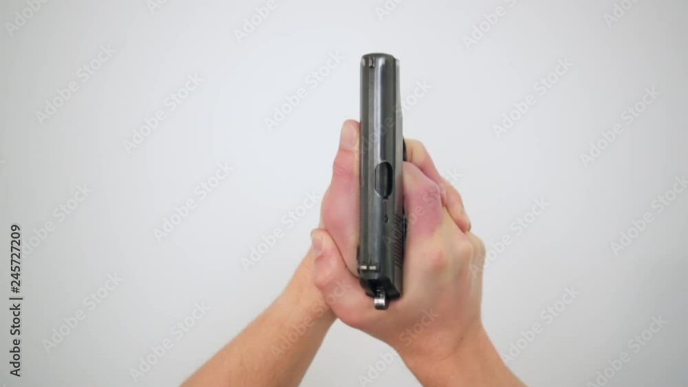 Top view male sniper hands holding black original pistol close-up high angle. Enthusiastic man ready to shooting by gun isolated at white studio background Top view male sniper hands holding black original pistol close-up high angle. Enthusiastic man ready to shooting by gun isolated at white studio background