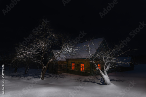 Obraz na płótnie Russia, Night Winter Christmas Landscape With Old Snow-Covered Fairy Tale House Among Snowdrifts And Trees. Ancient Russian Old Wooden House With Glowing Red Windows On Epiphany ( Christening ) Night w salonie