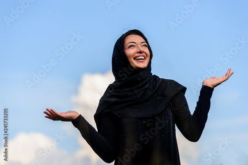 Beautiful middle eastern woman filling joy in the cloudy sky packground. photo