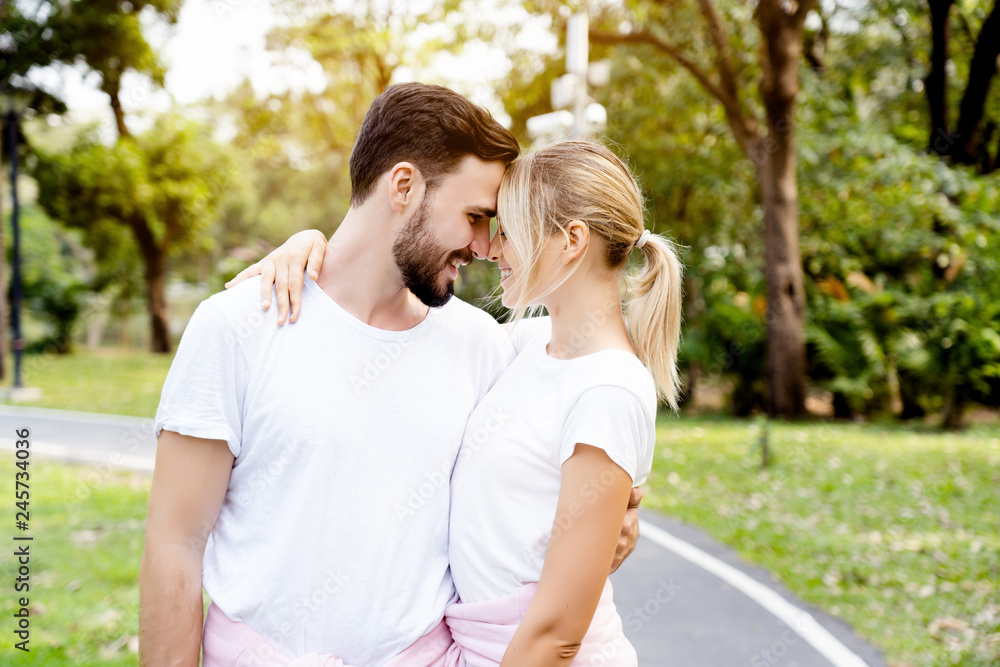 Caucasian Couples, men and women standing facing the nose, colliding And hugging in the garden In good weather in the morning of summer With fresh breath from good oral health care