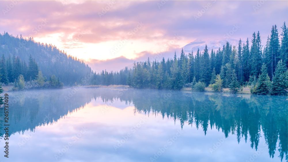 Water reflection of Cascade lake with morning mist and sunrise , Banff National park