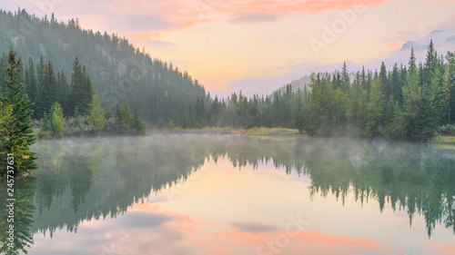 Morning mist on the Cascade Pond with beautiful water reflection at Banff National park