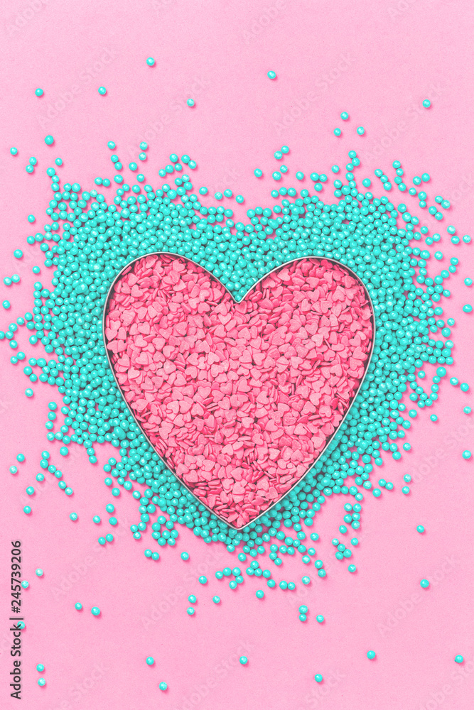Pink and mint colors cake sprinkles sweets heart shape on pink background with copy space, flat lay. Love, Mothers and Valentines Day and charity concept