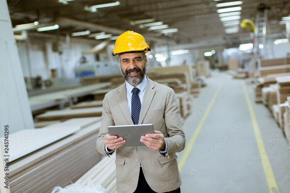 Middle-aged businessman with digital tablet in factory Middle-aged businessman with digital tablet in factory
