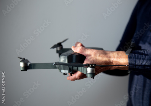 Flying mini drone and old man hand