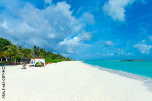 tropical Maldives island with white sandy beach and sea