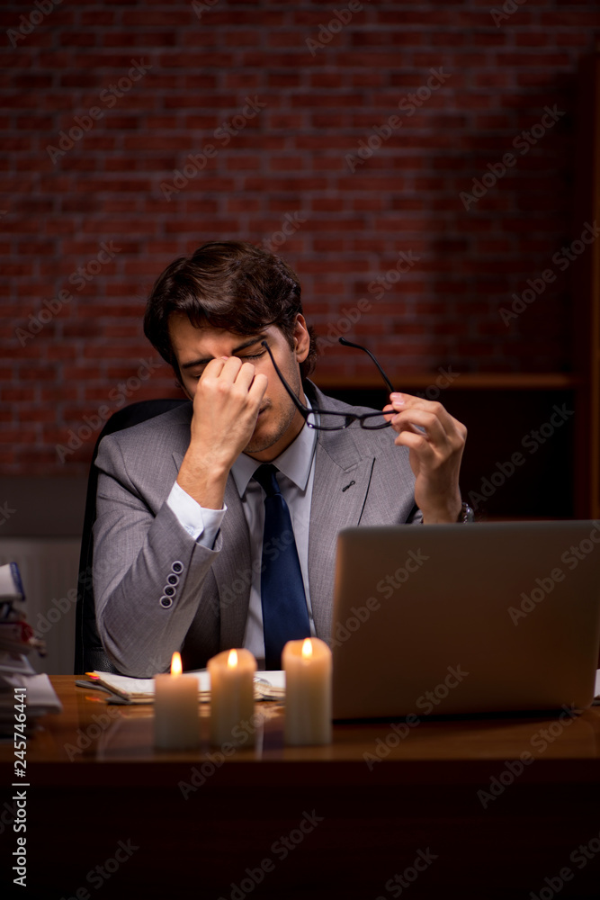 Businessman working late in office with candle light Businessman working late in office with candle light