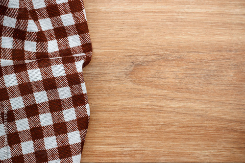 Brown checkered tablecloth, wooden table, top view