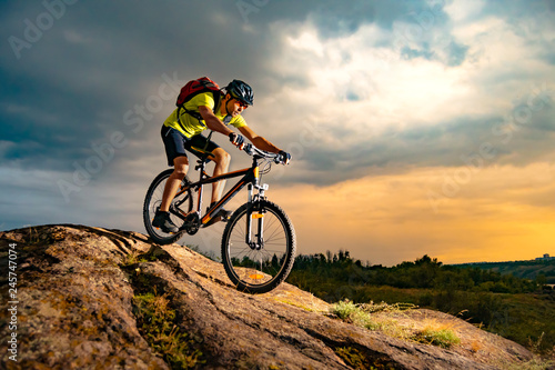 Fototapeta Naklejka Na Ścianę i Meble -  Cyclist Riding the Mountain Bike on Rocky Trail at Sunset. Extreme Sport and Enduro Biking Concept.