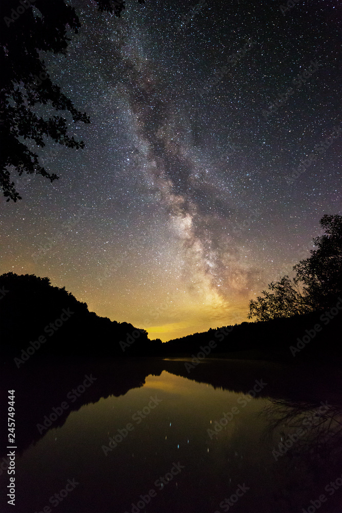 Milky Way galaxy photographed from a lake shore in a Starry Landscape Park.