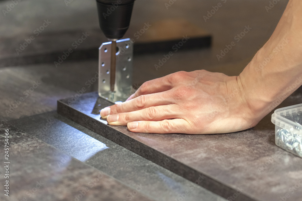 master assembles wood panels with a screwdriver master assembles wood panels with a screwdriver