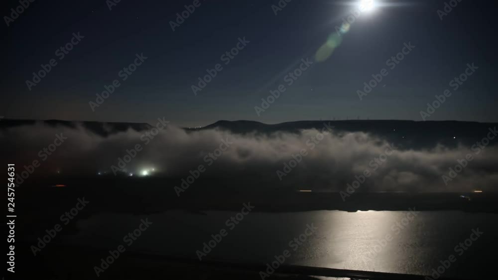 Flying over the deep night timelapse clouds with moon light. Flight through moving cloudscape over night city lights. Flying over the deep night timelapse clouds with moon light. Flight through moving cloudscape over night city lights.