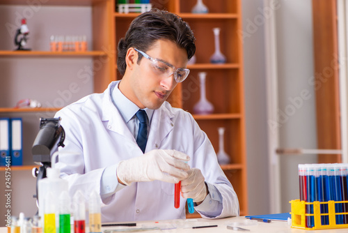 Young handsome biochemist working in the lab 