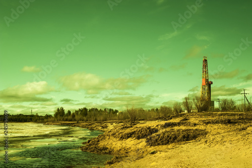 Landscape with a drilling rig at an oil field. Sunny day, early spring. Industrial landscape. Russia, Western Siberia.