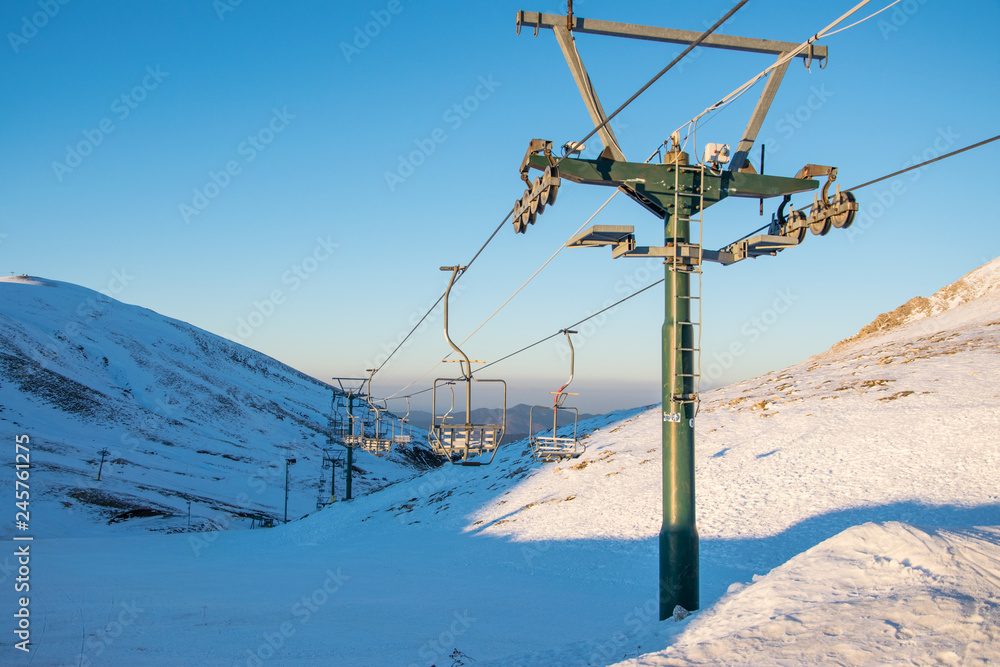 Empty chairlifts in a ski resort going over the snow covered mountain Empty chairlifts in a ski resort going over the snow covered mountain