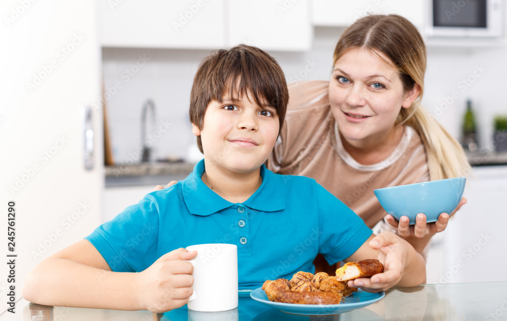Mother and son eating at kitchen