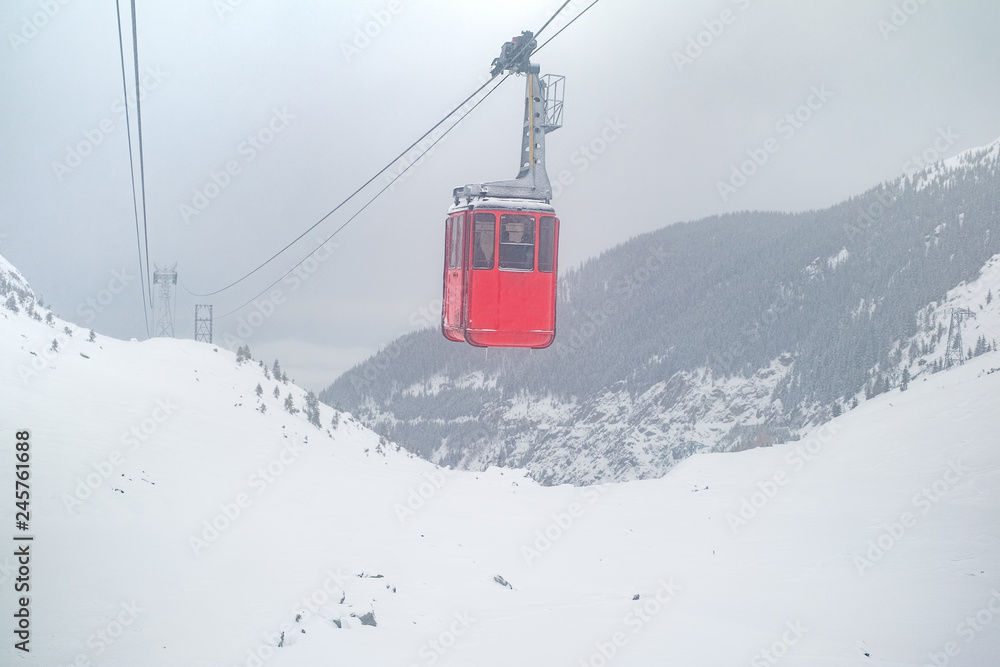 red cable car on snow storm