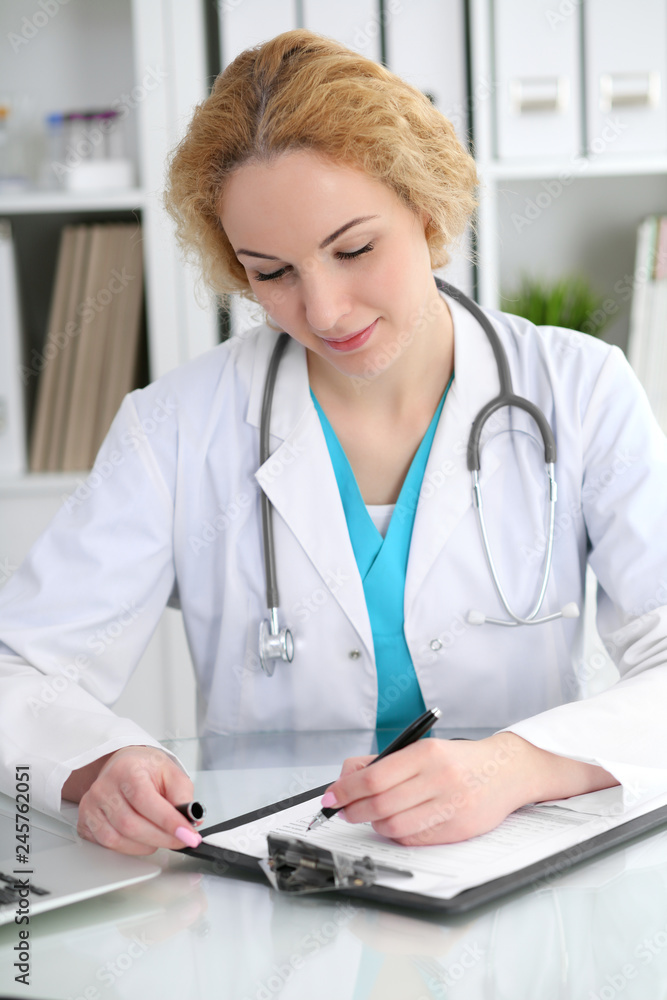 Doctor woman at work. Physician filling up medical history records form at the desk. Medicine, healthcare concept Doctor woman at work. Physician filling up medical history records form at the desk. Medicine, healthcare concept