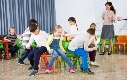 Фотография Pupils with teacher playing musical chairs