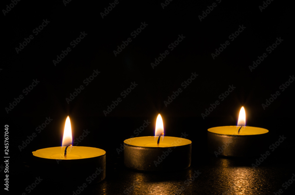 Three burning candles isolated on black background. Three burning candles isolated on black background.