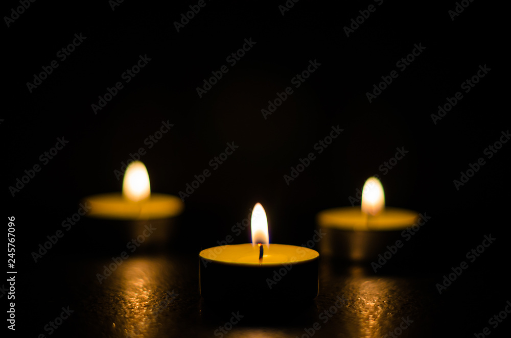 Three burning candles isolated on black background. Three burning candles isolated on black background.