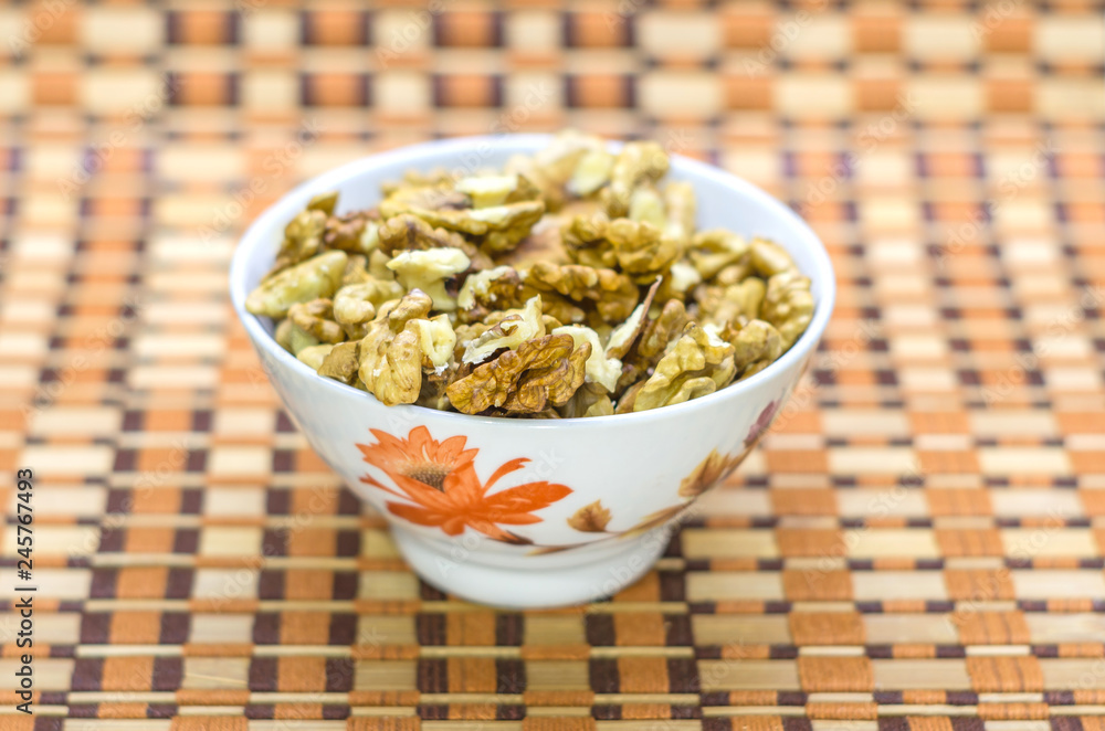 Walnuts in a white bowl on a brown beautiful background. Walnuts in a white bowl on a brown beautiful background.