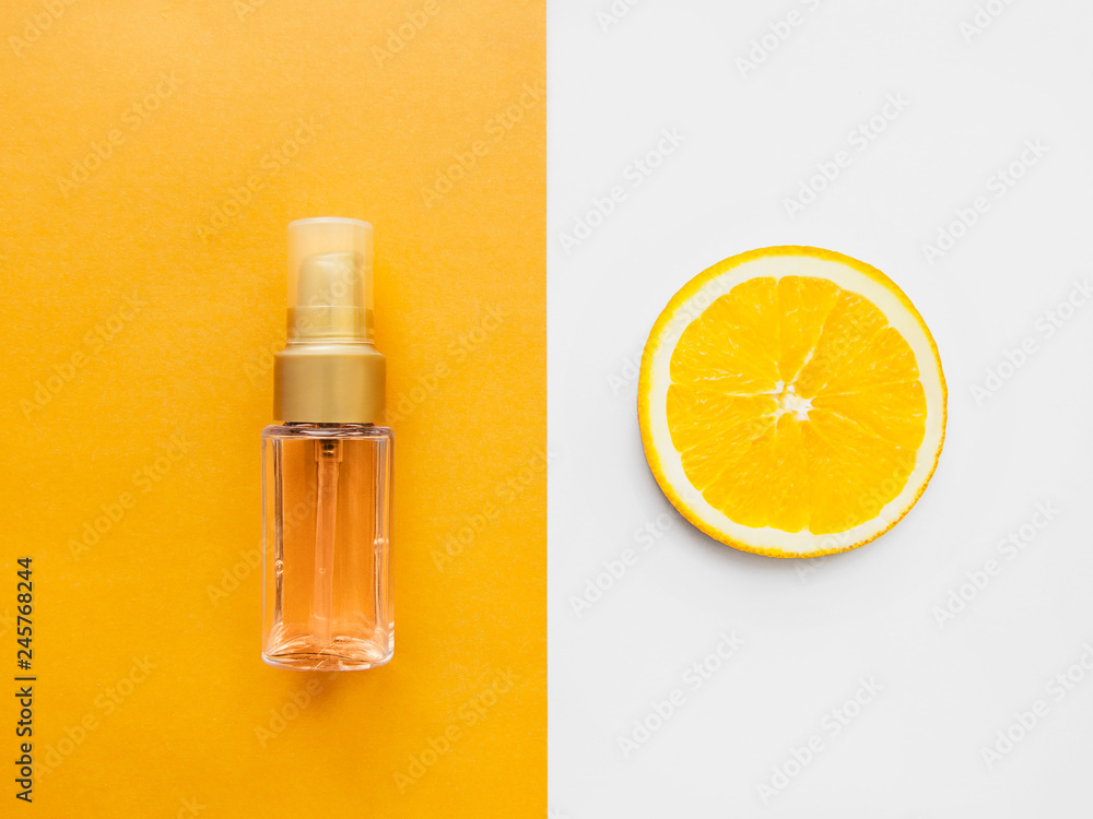Skincare Top view photo Cosmetic oil in the dispenser bottle and half of orange are lying on a two-tone background Mockup in a flat lay Skincare Top view photo Cosmetic oil in the dispenser bottle and half of orange are lying on a two-tone background Mockup in a flat lay