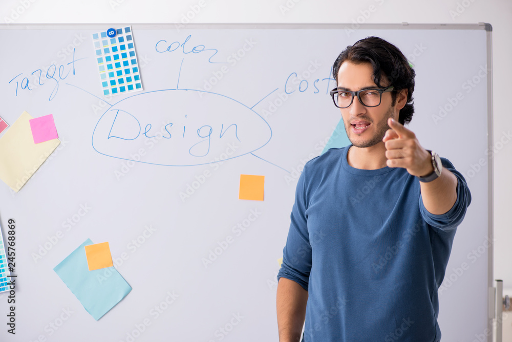 Young handsome designer working at the project Young handsome designer working at the project
