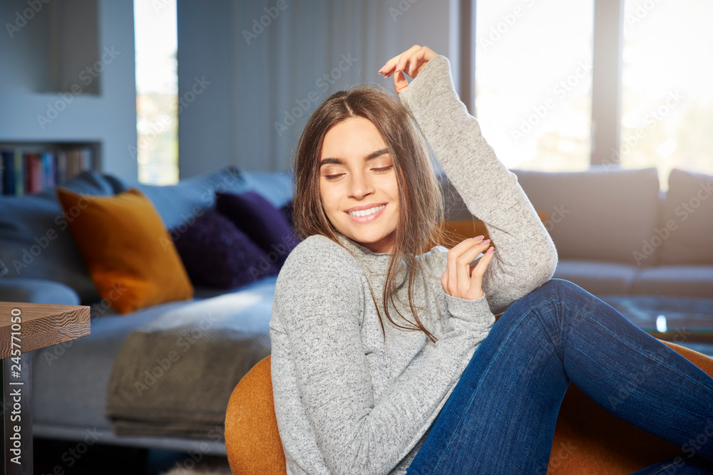 Relaxed young woman daydreaming in armchair at home Relaxed young woman daydreaming in armchair at home