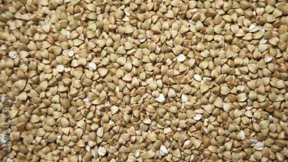 Green not roasted buckwheat groats as natural food background. Top view. Healthy diet gluten free Green not roasted buckwheat groats as natural food background. Top view. Healthy diet gluten free