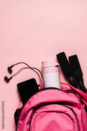 Sports bag and accessories on pink background