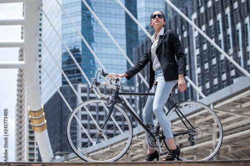 Business woman riding bicycle to work on urban street in city .transport and healthy . fashion lifestyle cool smart.