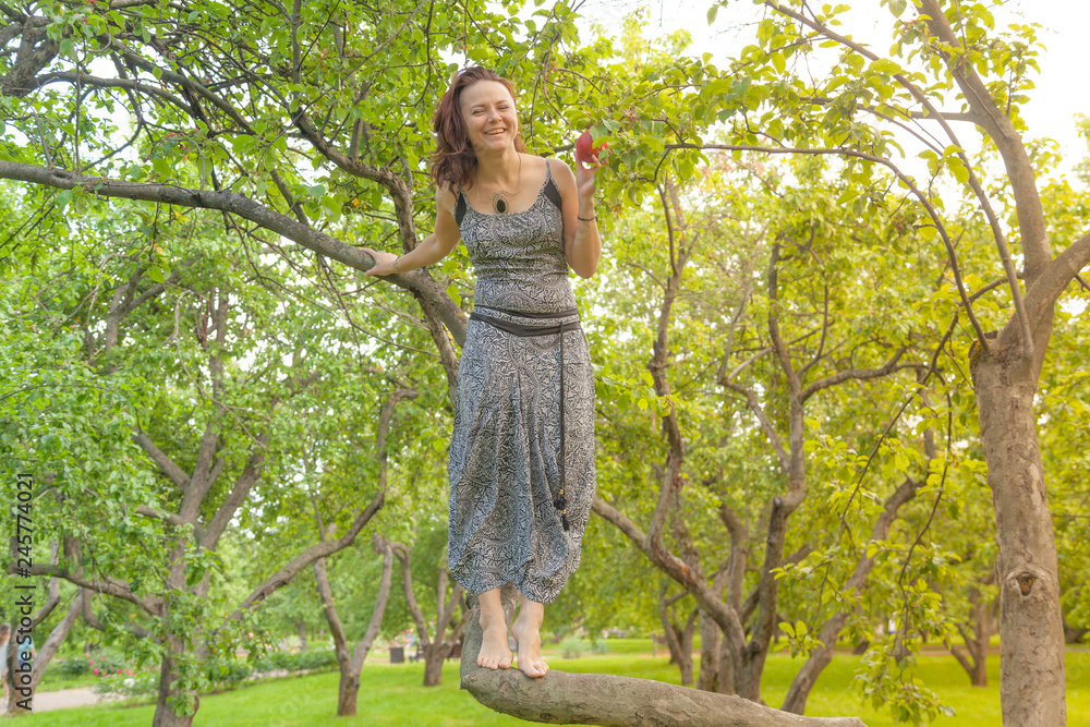 smiling red-haired alternative girl with shaved walks in a Sunny Apple orchard on a Sunny summer day smiling red-haired alternative girl with shaved walks in a Sunny Apple orchard on a Sunny summer day