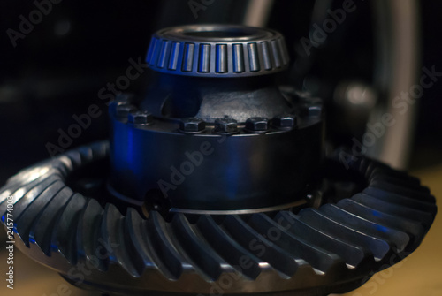 Foto massive metal detail - shaft with tapered roller bearing and spiral bevel gear wheel - on a dark background