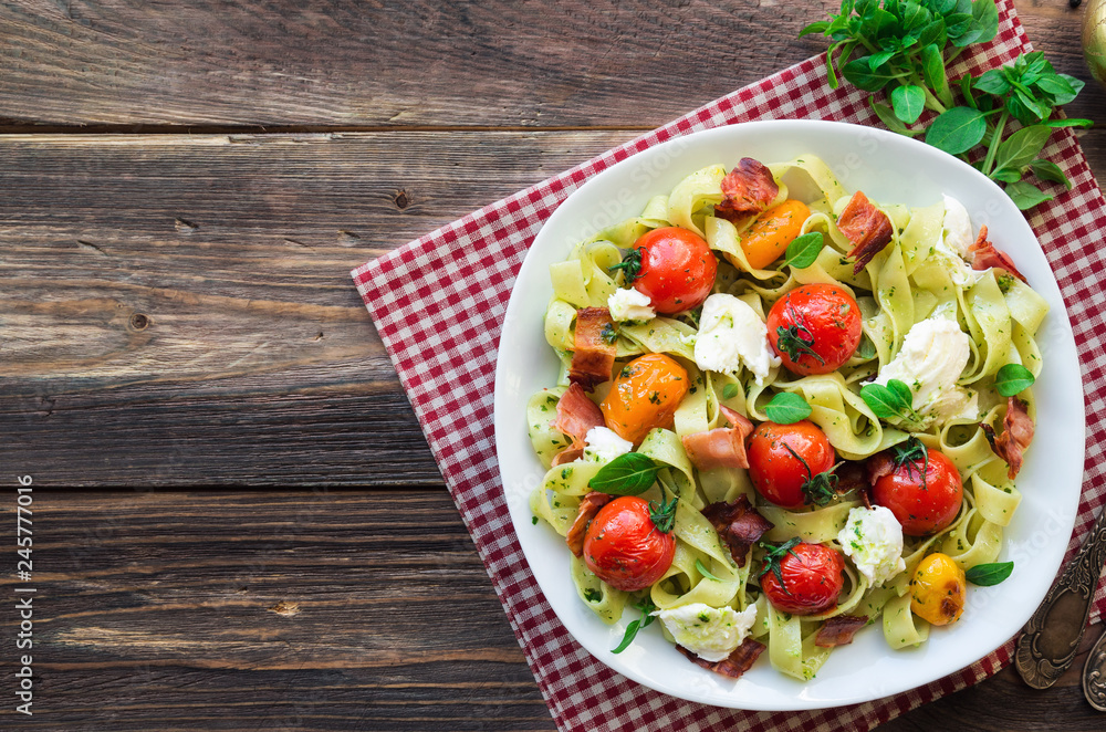 Fettuccine pasta with baked tomatoes, bacon and mozzarella cheese Fettuccine pasta with baked tomatoes, bacon and mozzarella cheese